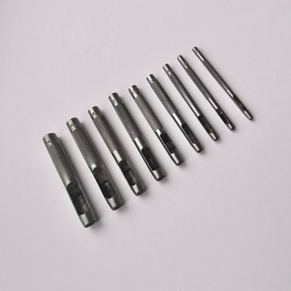 Set of metal leather drive punch tools on a grey background