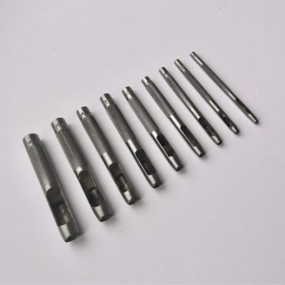Set of metal leather drive punch tools on a grey background