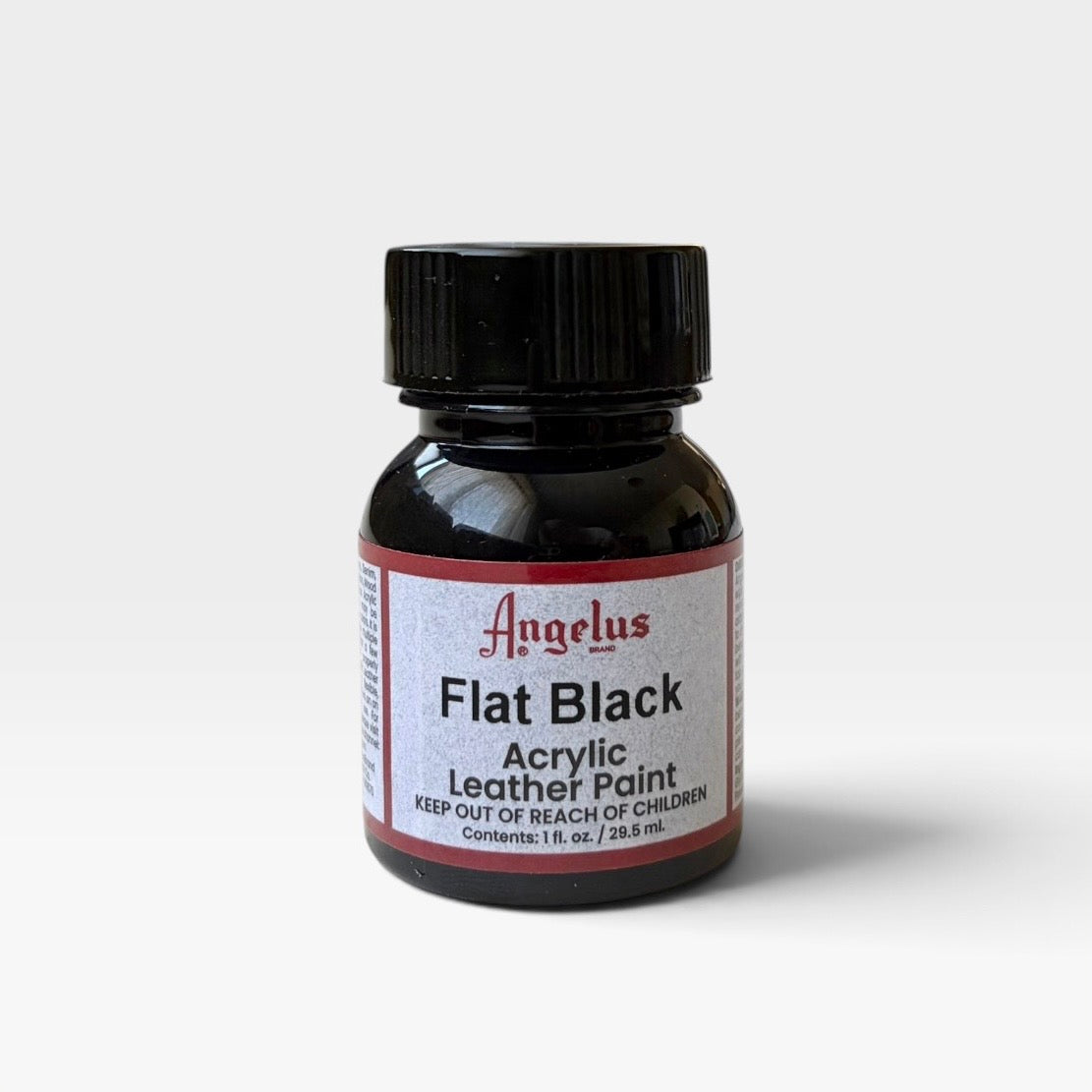 A small bottle of Angelus Flat Black acrylic leather paint, featuring a black cap and a white label with red borders, set against a plain light gray background.