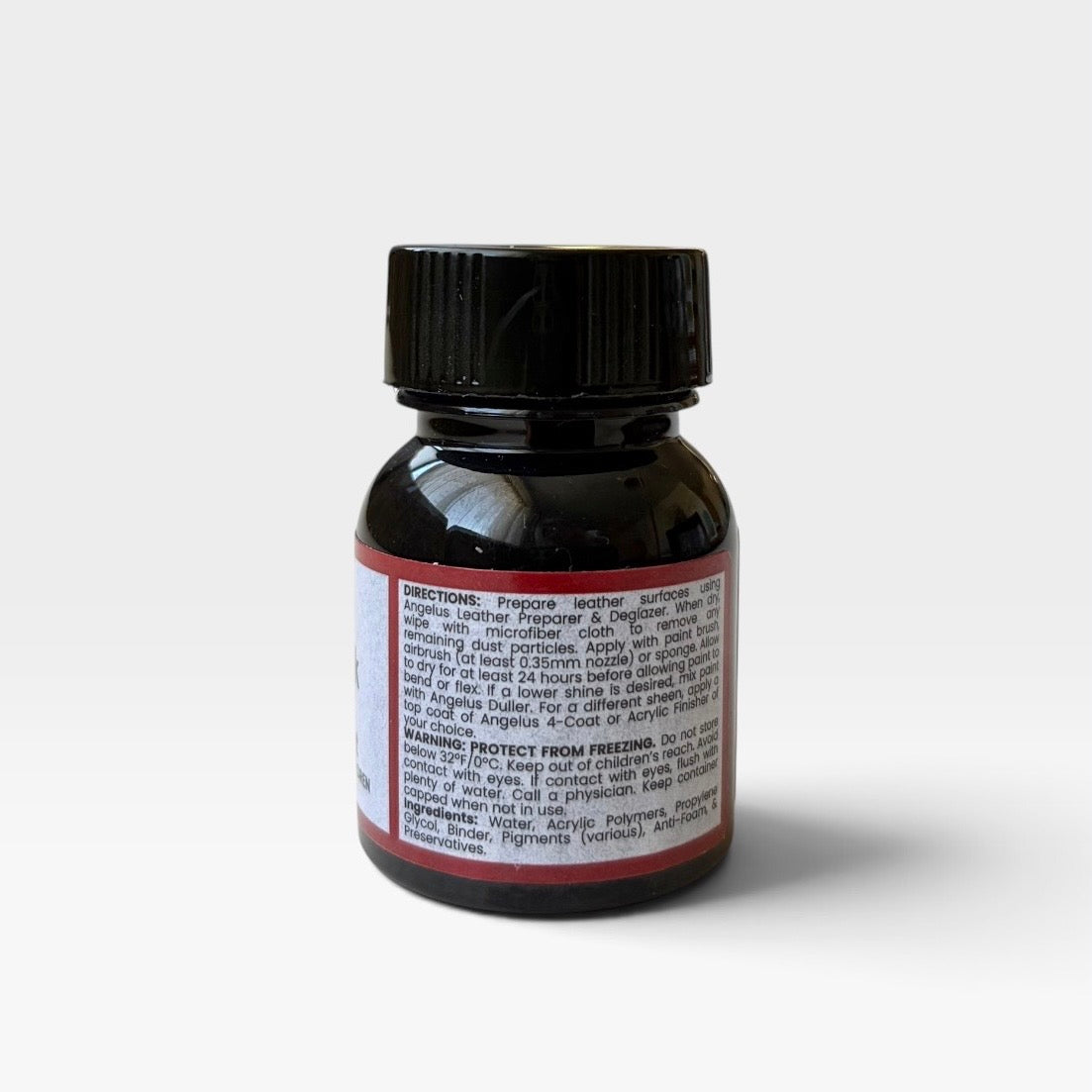 The back of a small bottle of Angelus Flat Black acrylic leather paint, featuring a black cap and a white label with red borders, set against a plain light gray background.