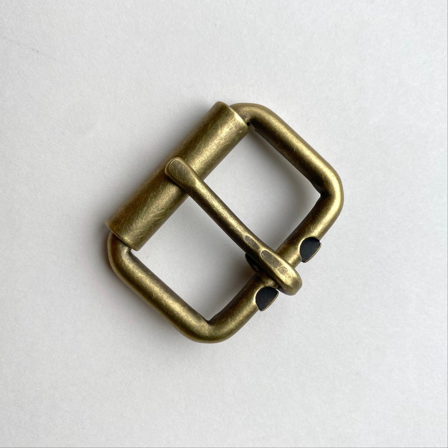 Bronze belt buckle on a light gray background