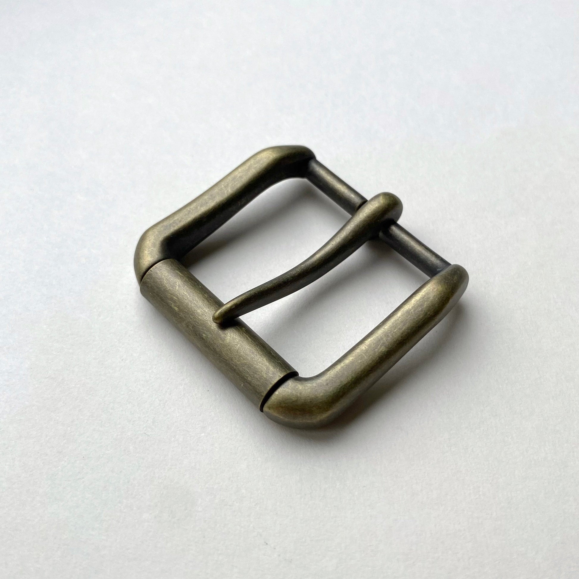 Bronze belt buckle on a light gray background