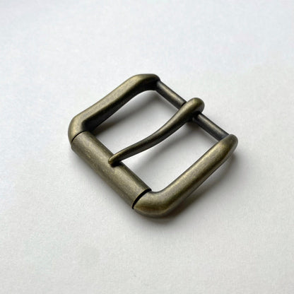 Bronze belt buckle on a light gray background