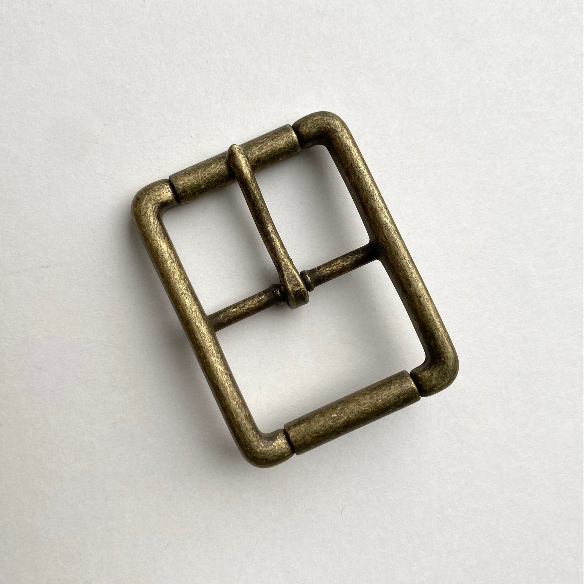Bronze metal buckle on a light gray background