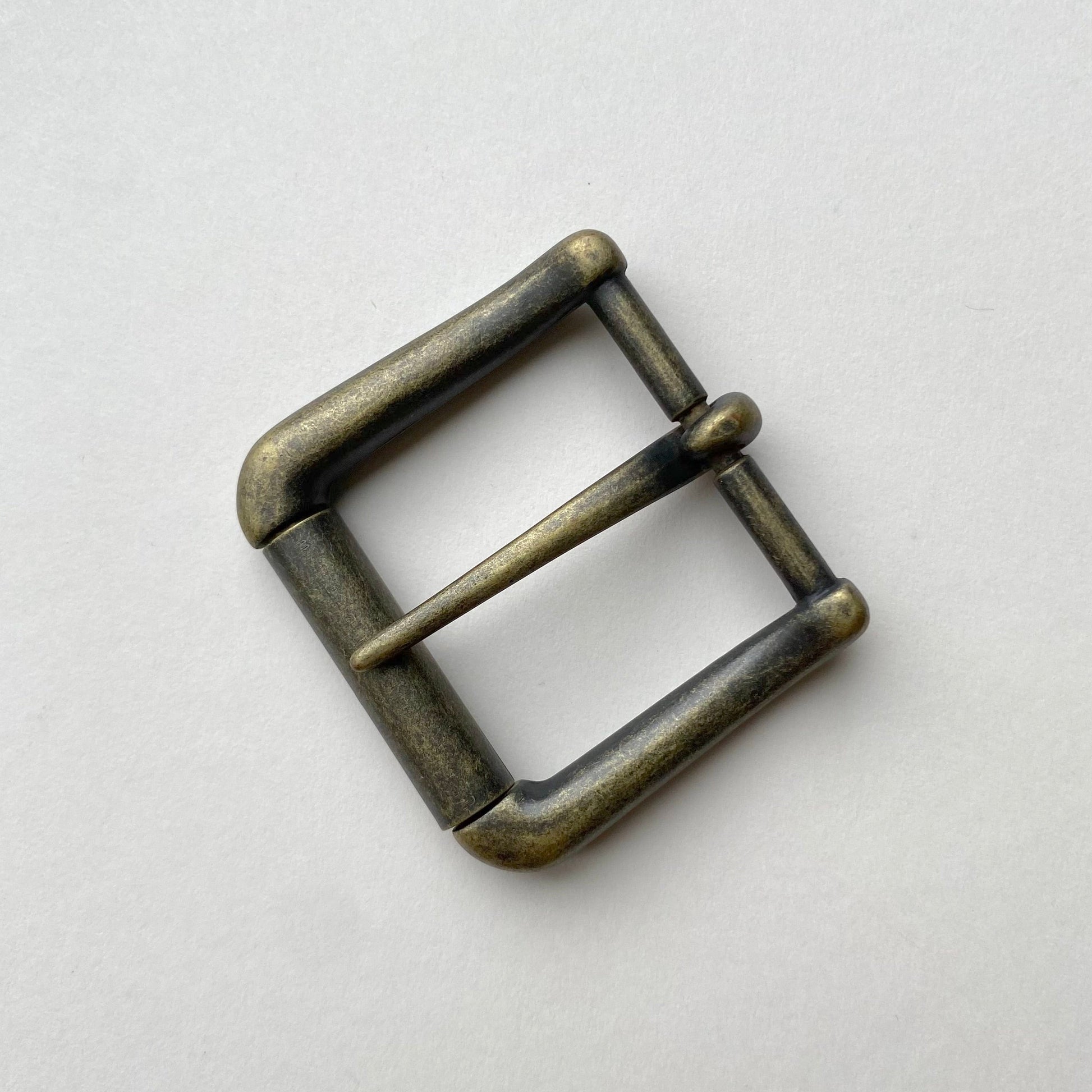 Bronze-colored belt buckle on a light gray background