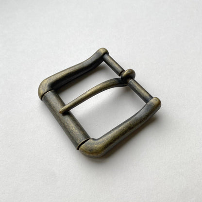 Bronze belt buckle on a light gray background
