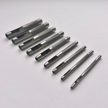 Set of metal leather drive punch tools on a grey background