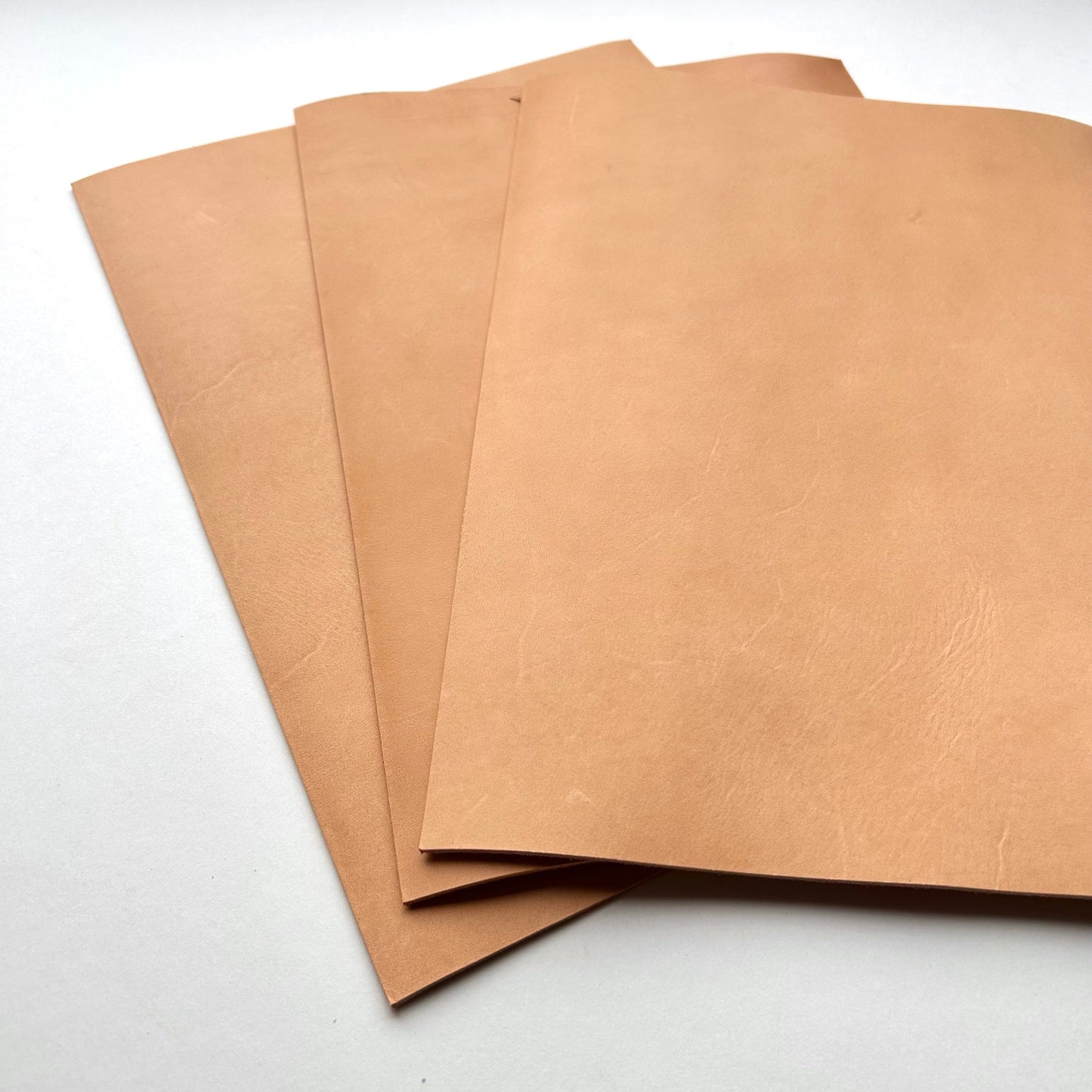 Three pieces of natural leather on a white background
