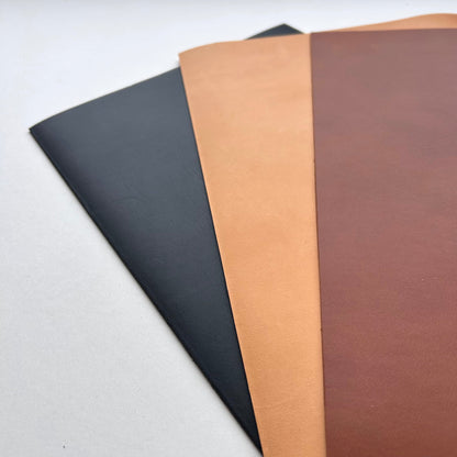 Three sheets of leather material in black, brown, and beige on a white background.