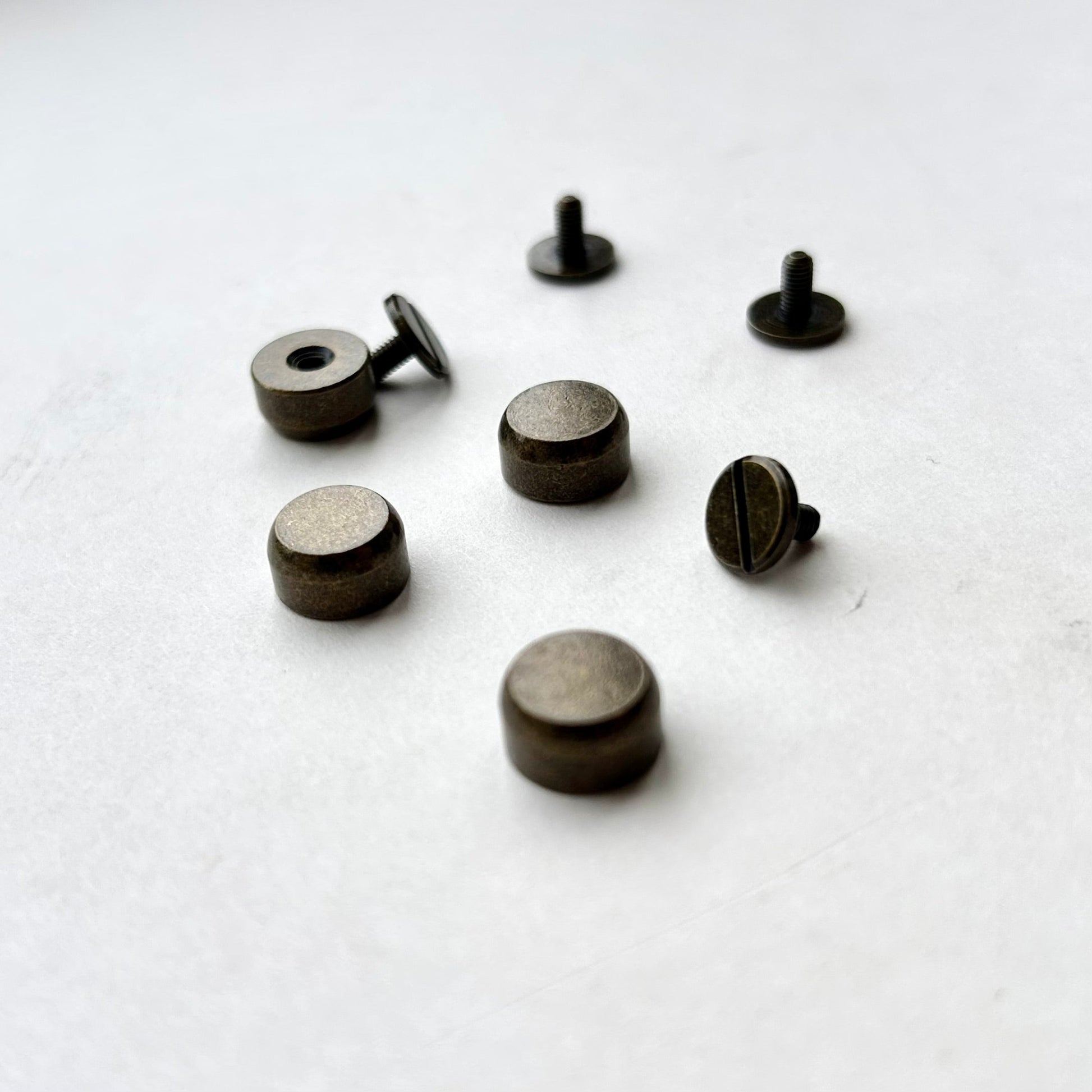 Set of antique brass metal bag feet studs on a white background