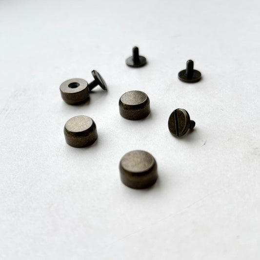 Set of antique brass metal bag feet studs on a white background