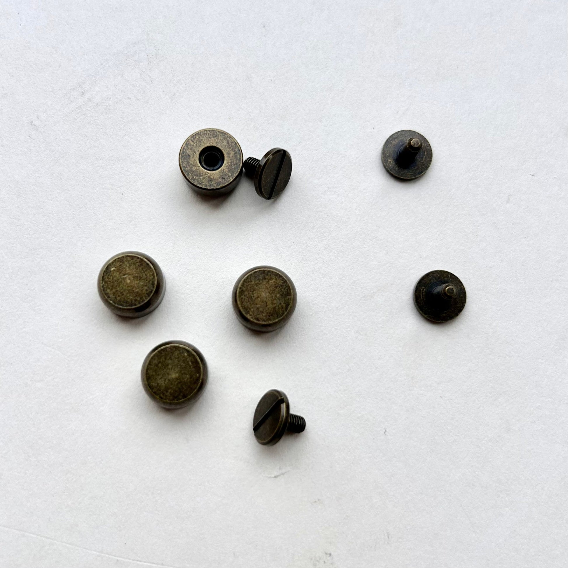 Set of antique brass metal bag feet studs on a white background