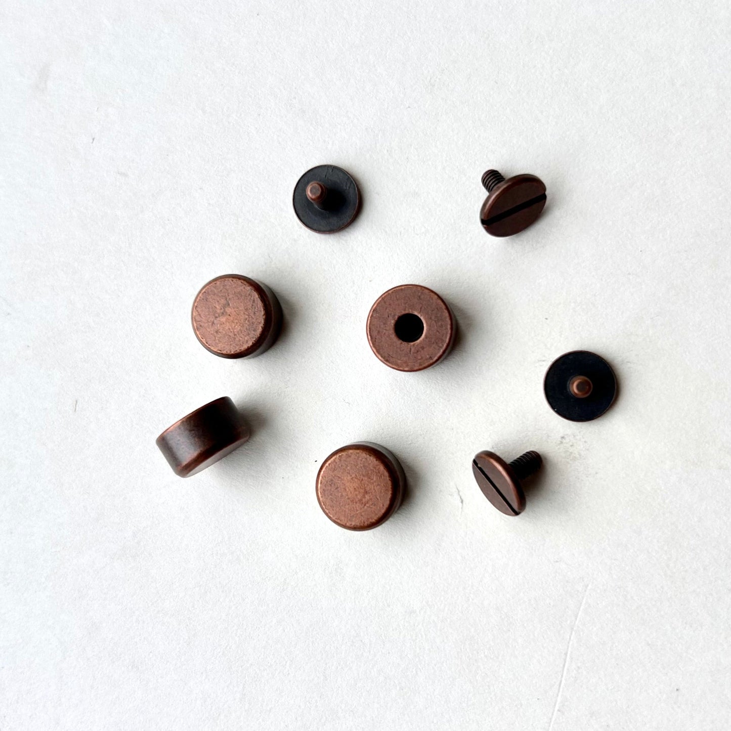 Set of copper screw feet on a white background