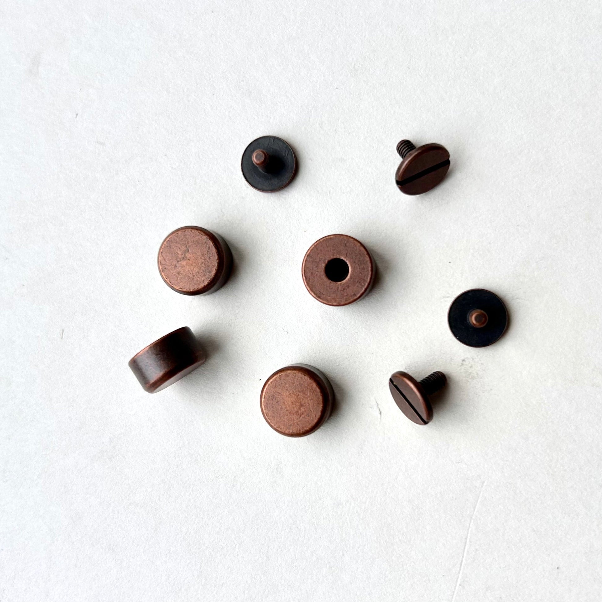 Set of copper screw feet on a white background