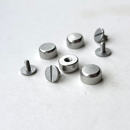 Set of metal screw bag feet in silver on a white background