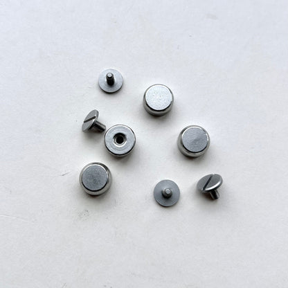 Set of metal screw bag feet in silver on a white background