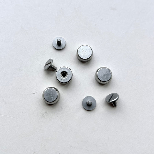 Set of metal screw bag feet in silver on a white background