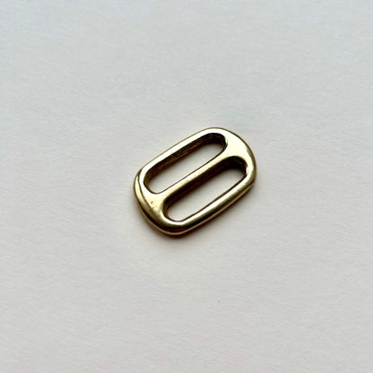 Gold brass metal belt slide on a white background