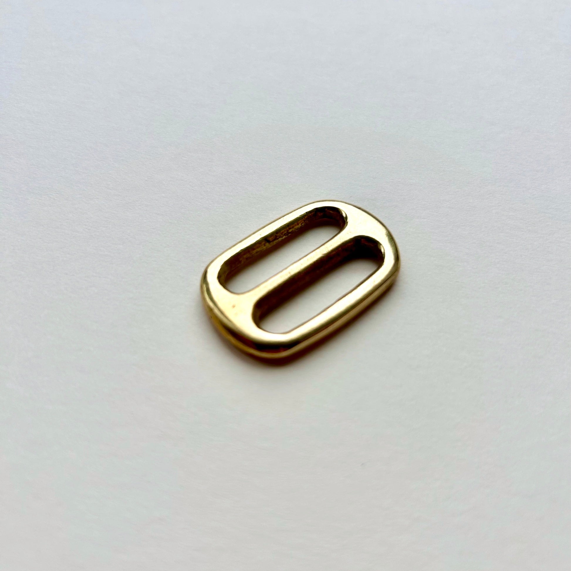 Gold brass metal belt slide on a white background
