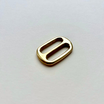 Gold brass metal belt slide on a white background