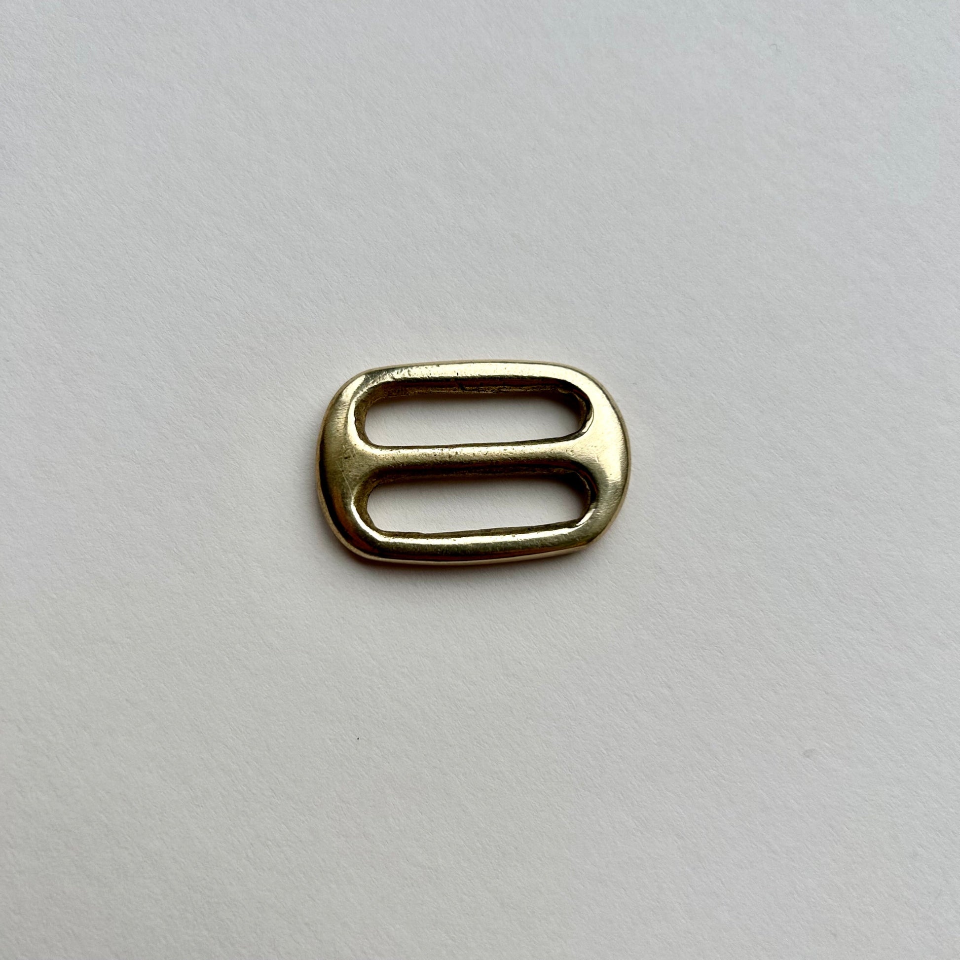 Gold brass metal belt slide on a white background