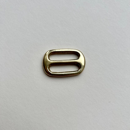 Gold brass metal belt slide on a white background