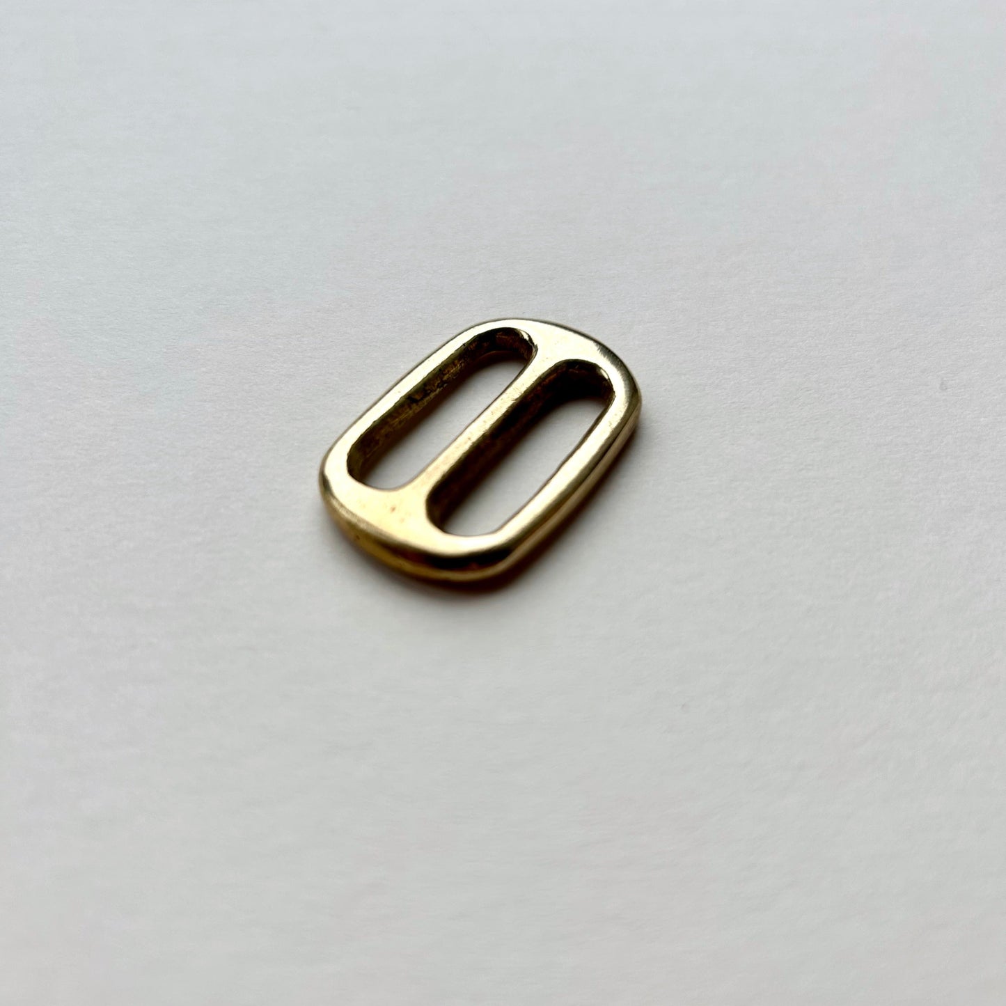 Gold brass metal belt slide on a white background