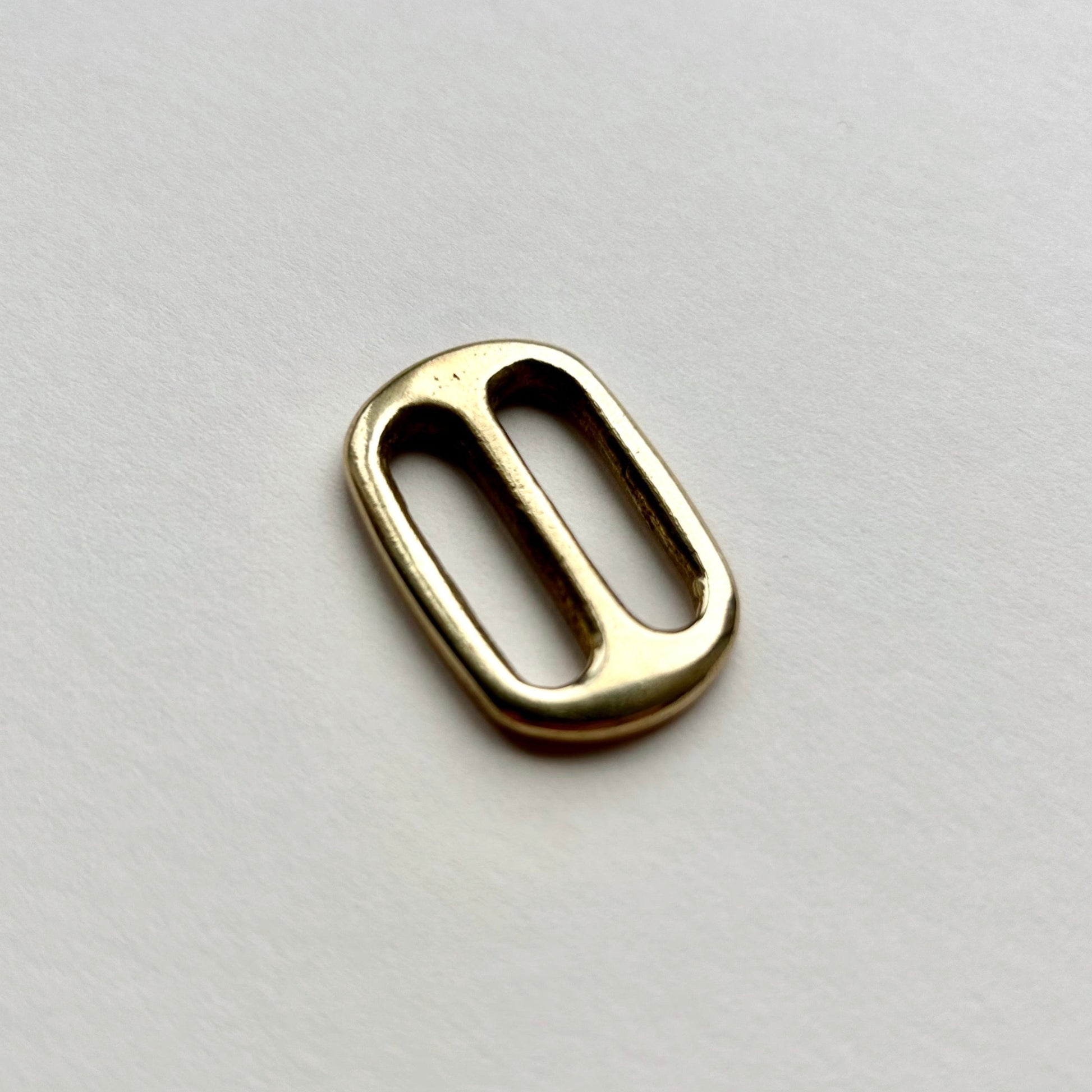 Gold brass metal belt slide on a white background