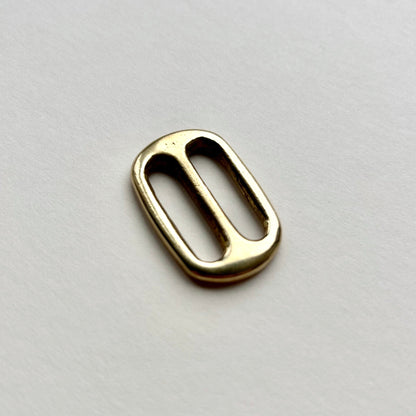 Gold brass metal belt slide on a white background