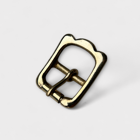 Brass belt buckle on a light gray background