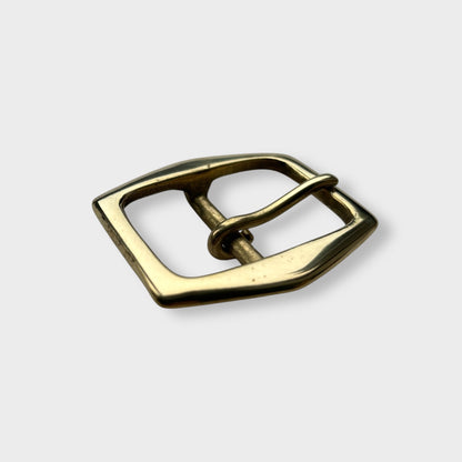 Gold coloured brass belt buckle on a light grey background, centre bar style.