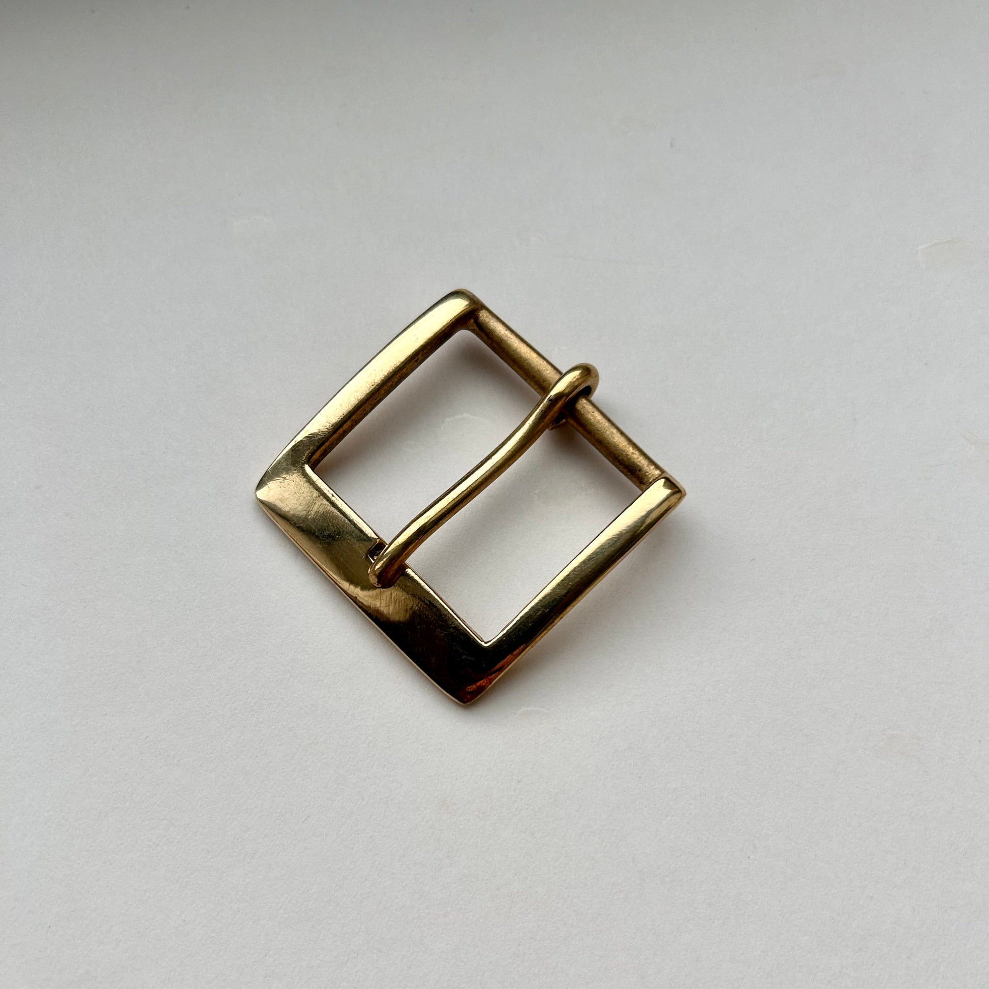 Solid brass buckle frame and pin style on grey background