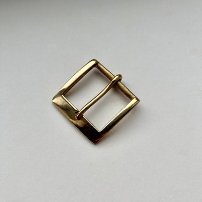 Solid brass buckle frame and pin style on grey background