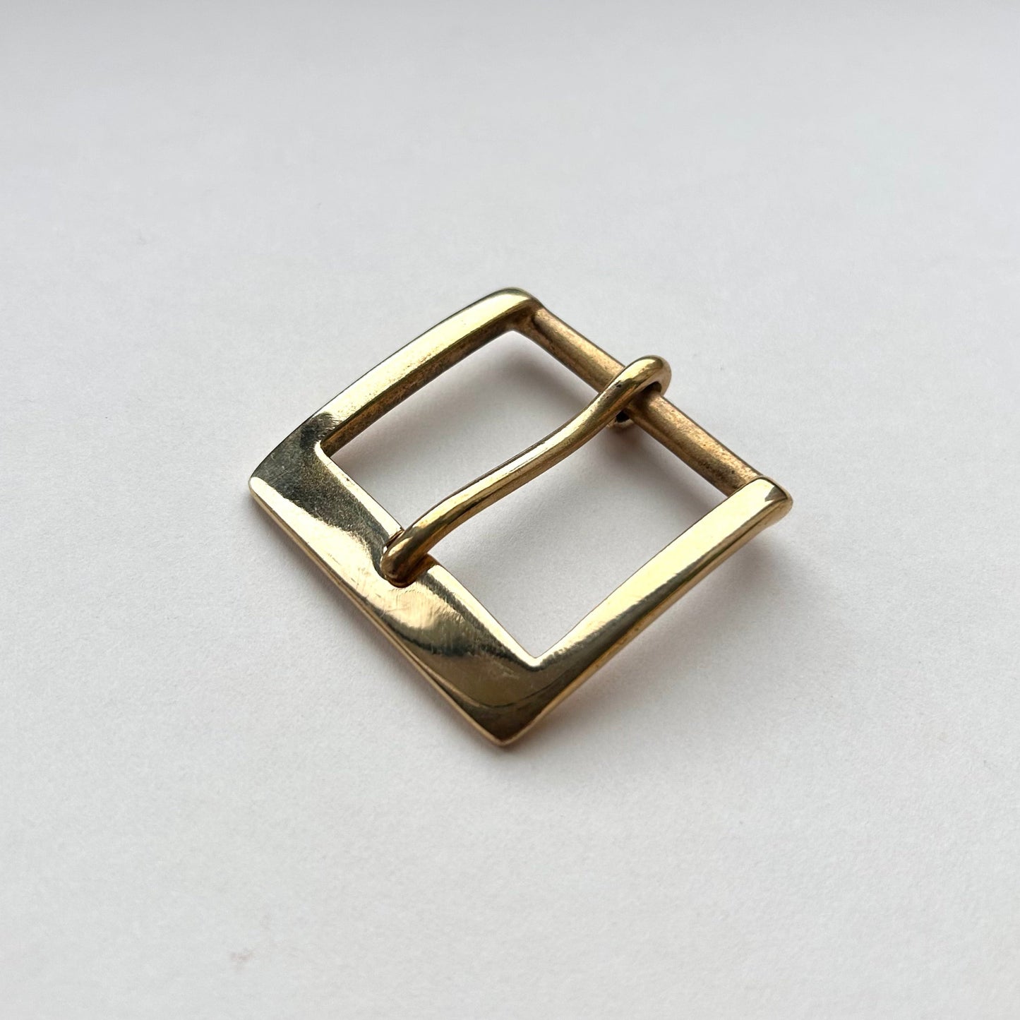 Solid brass buckle frame and pin style on grey background