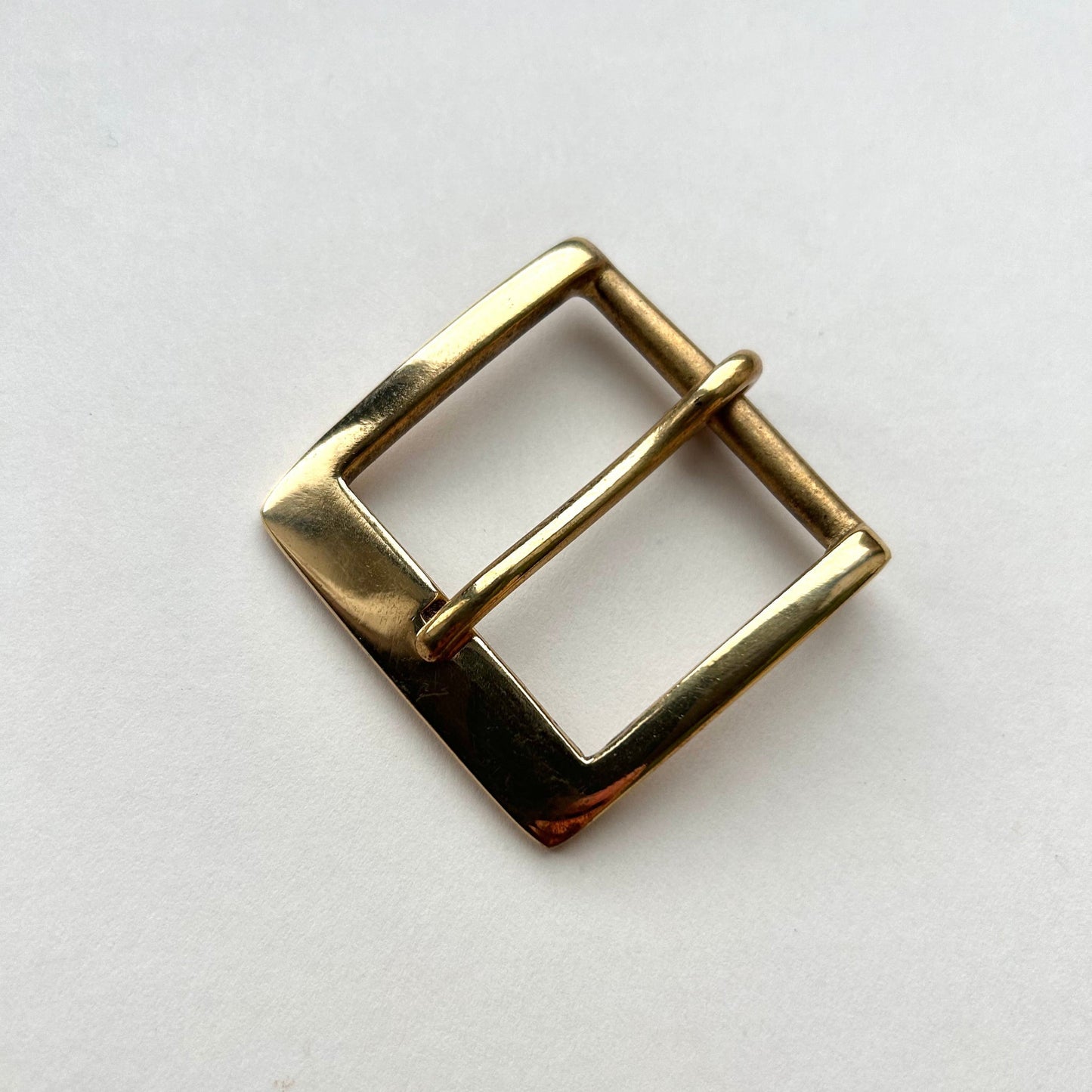 Solid brass buckle frame and pin style on grey background