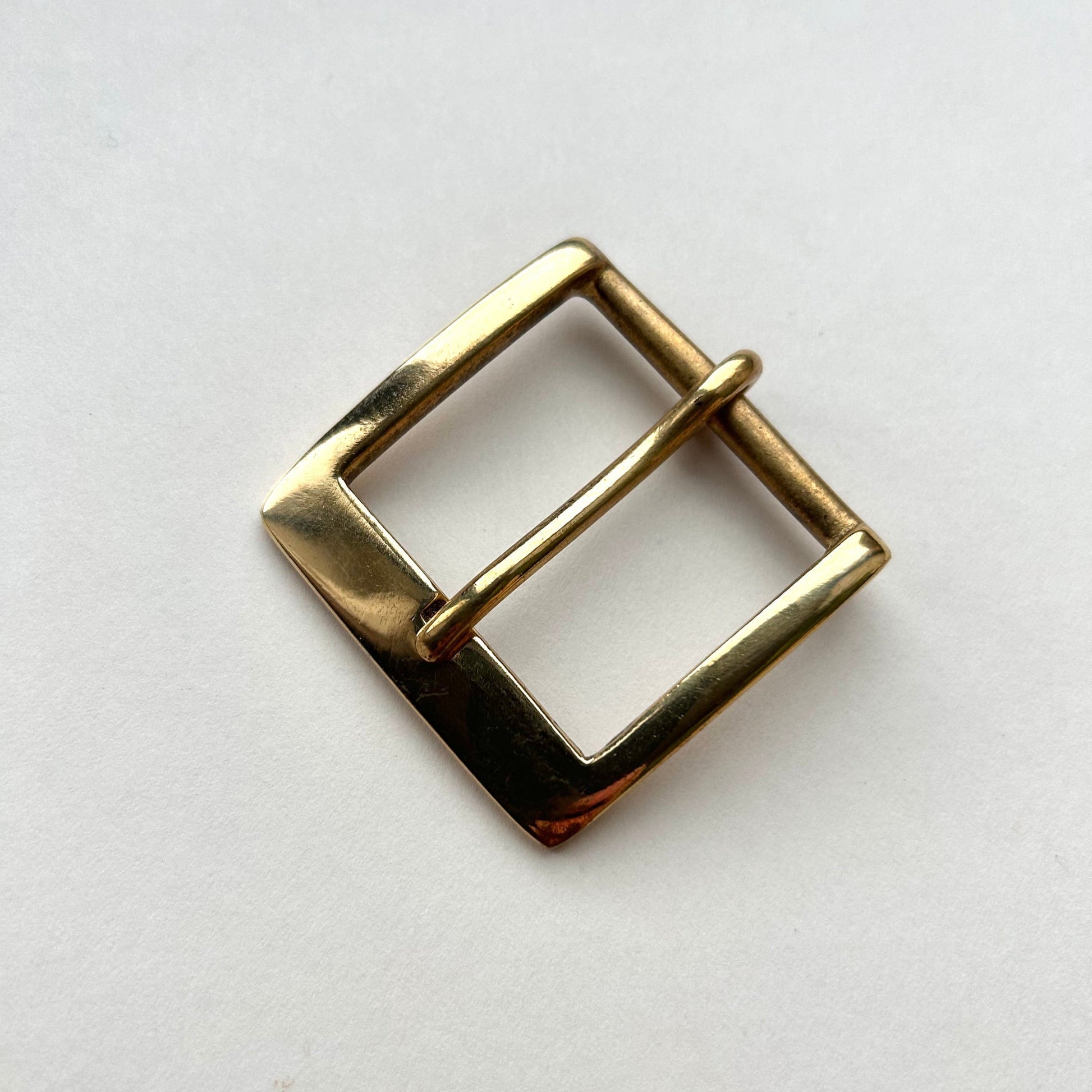 Solid brass buckle frame and pin style on grey background