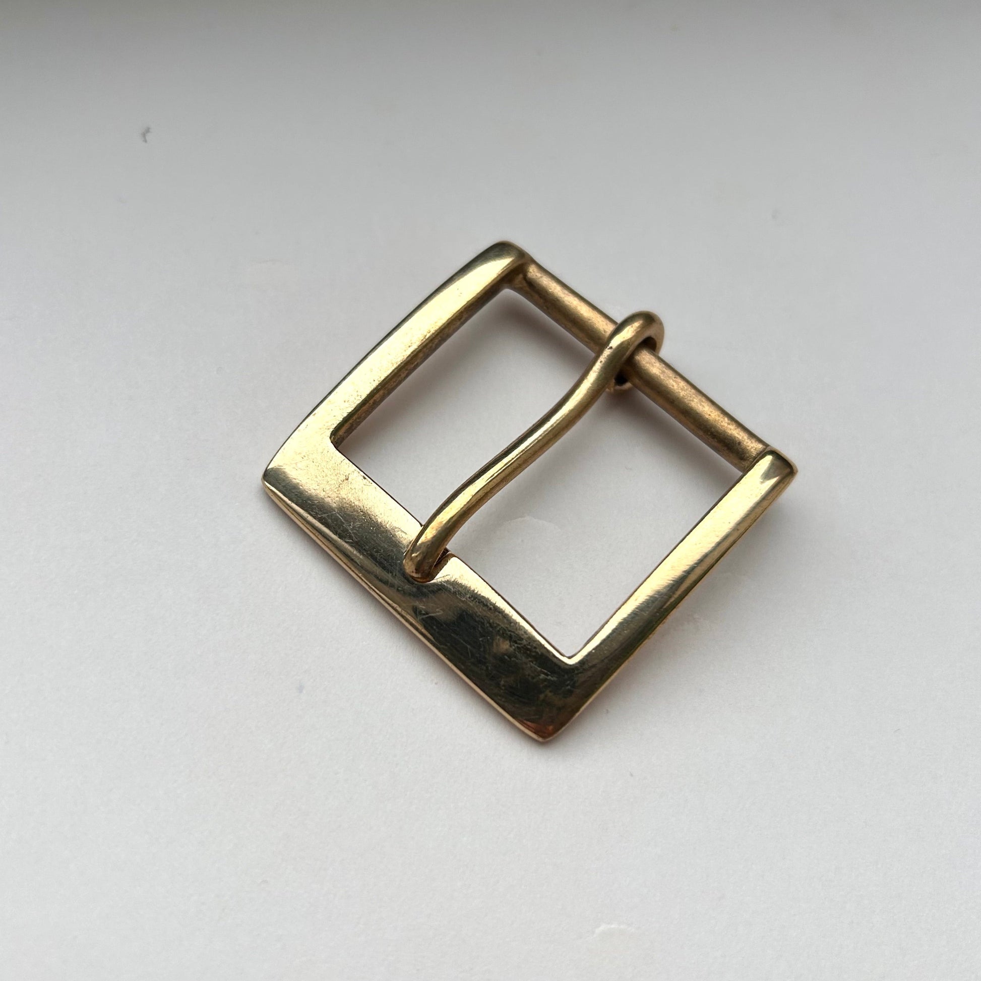 Solid brass buckle frame and pin style on grey background