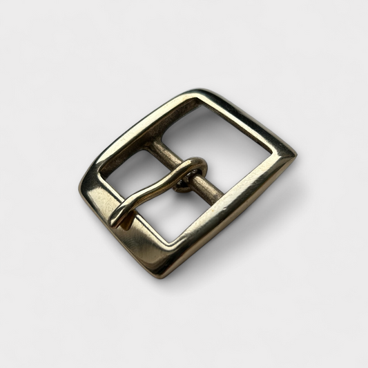 Gold metal buckle on a light gray background