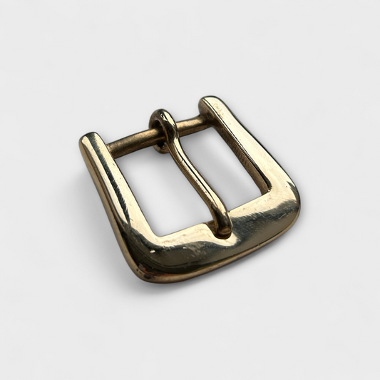 Gold metal buckle on a light gray background