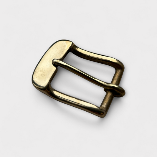 Gold belt buckle on a light gray background