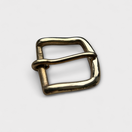 Gold metal buckle on a light gray background