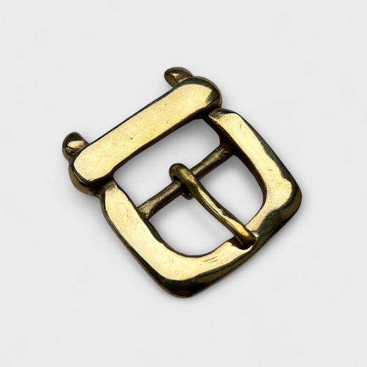Gold metal buckle on a light gray background