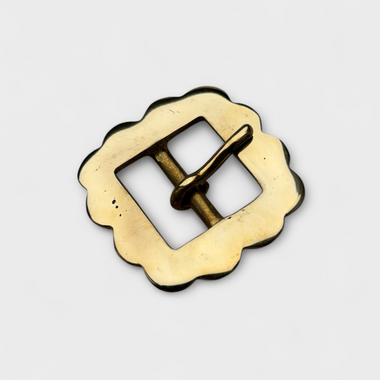 Gold metal buckle on a light gray background