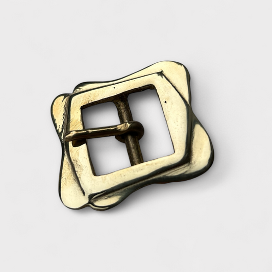 Gold metal buckle on a light gray background