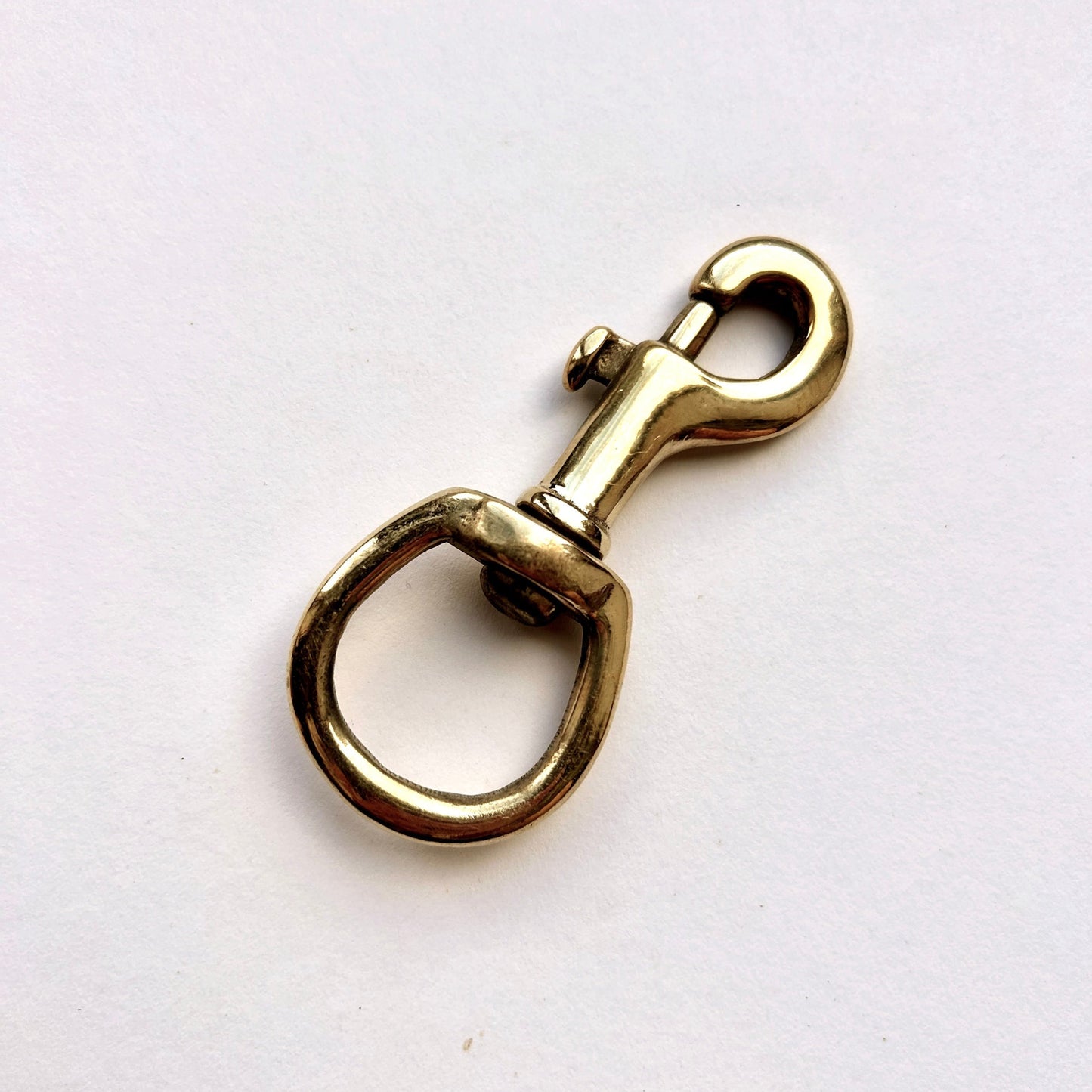 Brass swivel snap hook on a white background