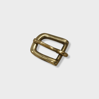 Brass buckle made in the UK on grey coloured background