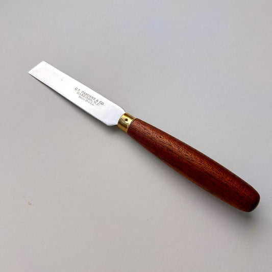 Wooden-handled knife with a metal blade on a gray background