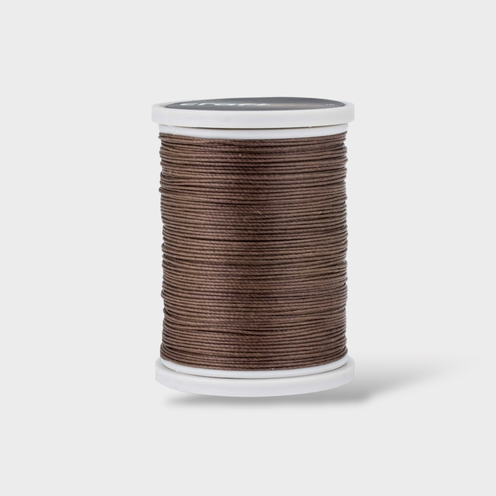 Spool of brown thread on a white background