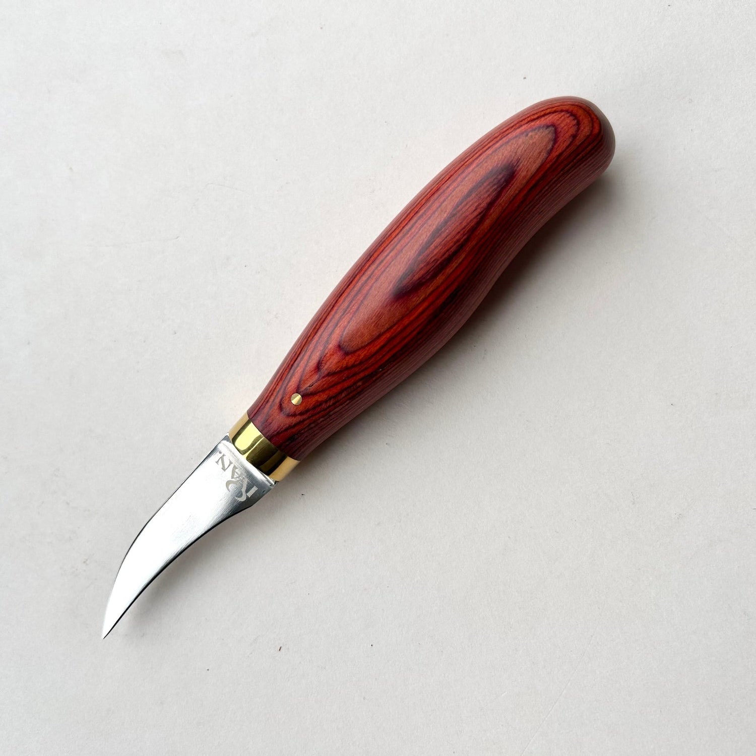 Wooden-handled clicker knife for leather with metal blade on a white background