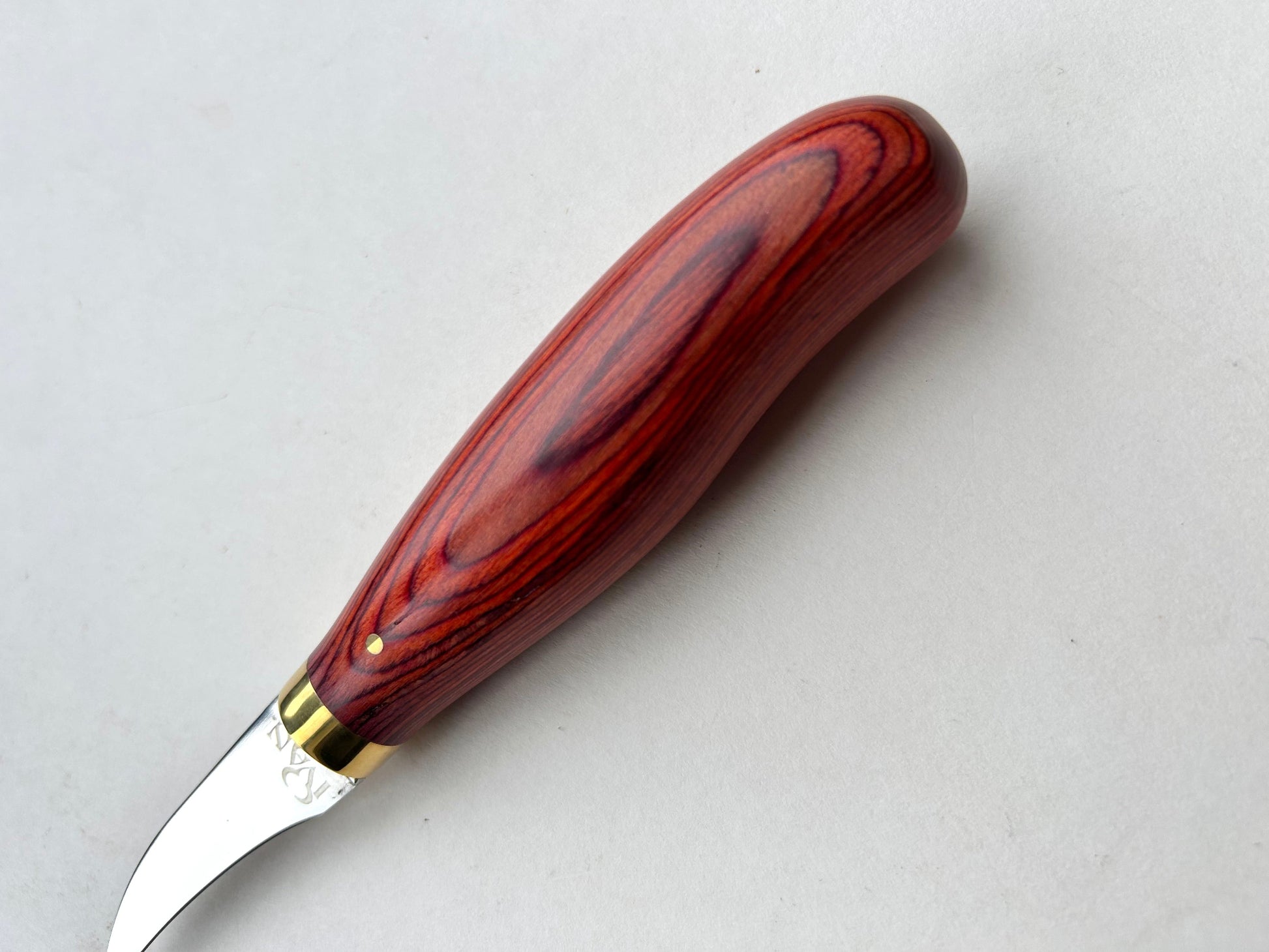 Wooden-handled clicker knife for leather with metal blade on a white background